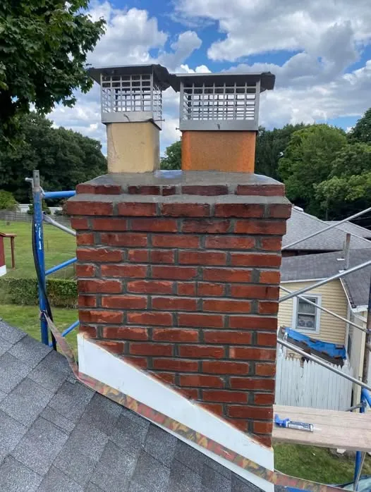 Rebuilt red brick chimney with new masonry caps