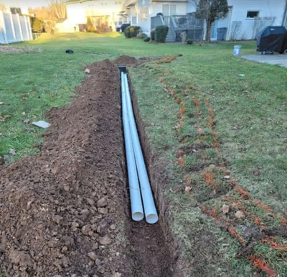 New PVC drain line set in a freshly dug backyard trench